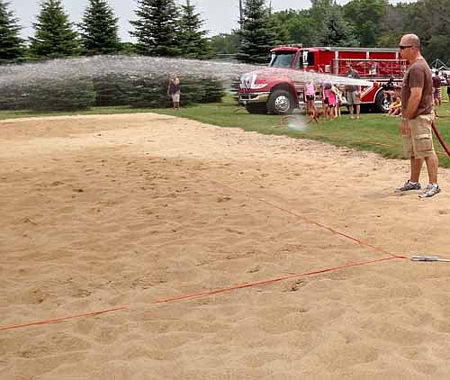 Vance Swisher of the Stewartville Fire Department hosed down the sand volleyball courts when the sand heated up during the afternoon games at the 2015 Summerfest Co-Ed Sand Volleyball tournament courts at Bear Cave Park. Tourney coordinator Trina Urban extended thanks to Swisher and the SFD as well as the city of Stewartville Park Board and Public Works Department.