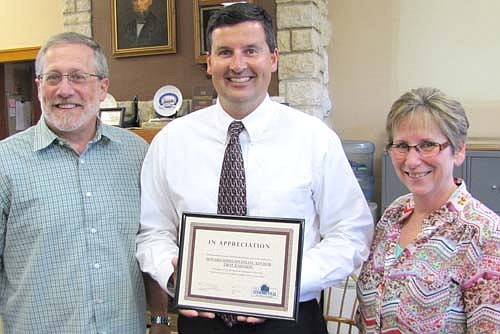 Troy Knutson, the financial advisor for Edward Jones of Stewartville, center, accepts the Business Appreciation Award from Stewartville's Economic Development Authority (EDA) at the EDA's regular meeting on Tuesday, July 21. Chris Stafford, president of the EDA, left, and Kari York, vice president, presented the award.