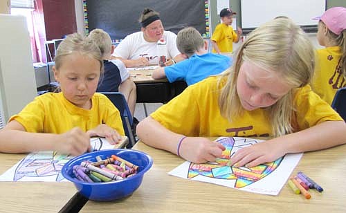 Kaydyn Strum, left, and Morgan Schild work on a coloring project at Tiger Time at Central Intermediate School last Thursday, July 23. Kaydyn and Morgan, 7-year-olds heading into second grade at Bonner Elementary School, both enjoy running and playing in the Central gym. "I'm faster than Morgan," Kaydyn said. "You don't know that," Morgan responded. "We haven't raced yet."
