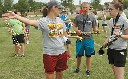 Jessica Honsey, director of the Stewartville High School Marching Band, above left,  advises students Nate Sikkink, center right, and Melanie Lex, right, during a break from marching at SHS Band Camp.