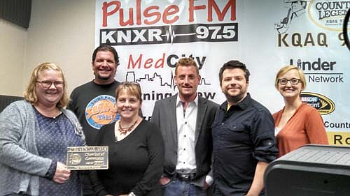 Members of the Stewartville Area Chamber of Commerce welcomed KNXR 97.5 Radio of Rochester to the Stewartville Area Chamber of Commerce with an official ambassador visit last week. Gwen Ravenhorst, Chamber administrator, presents a Chamber plaque to members of the KNXR 97.5 administration and staff, including Beau Jensen, tri-owner of the station, third from right. Melissa Sue Leuning, Chamber president, is at far right.