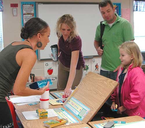  Jay and Mollie Forstner and their daughter Maizey, of rural Rochester, met Maizey's new first-grade teacher, Jessyca Williams, left, at the "one-stop shop" at Bonner Elementary School on Thursday morning, Aug. 20. Students met their teachers, signed up for school lunch, posed for their class pictures and took a vision test.
