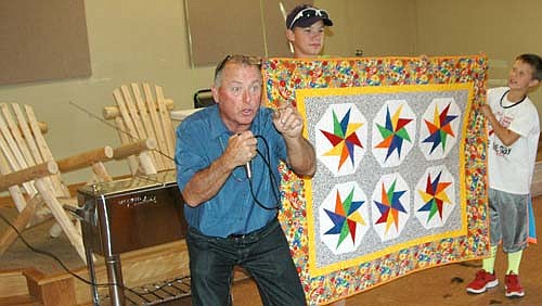 Stewartville Mayor Jimmie-John King, left, auctioned off a number of items in a live auction at the third annual Seize the Day, Cure Blood Cancers event at the Stewartville American Legion Post 164 on Sunday, Sept. 13. Live auction items included a quilt made by Wanda Prescher, above, Minnesota Wild photos and two log lawn chairs, at left above. In all, the event raised more than $8,000 to fight blood cancers such as leukemia, lymphoma and myeloma.