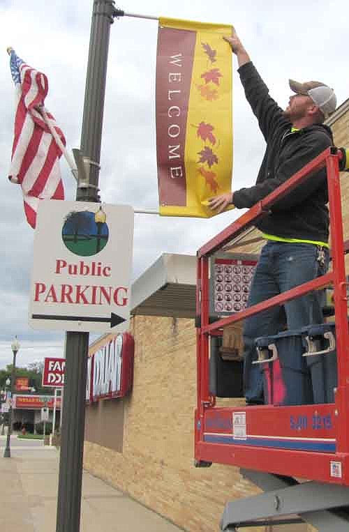 Jeff Norby of the city of Stewartville's public works department placed autumn banners on the light poles along Main Street on a cool and breezy Friday afternoon, Sept. 11.