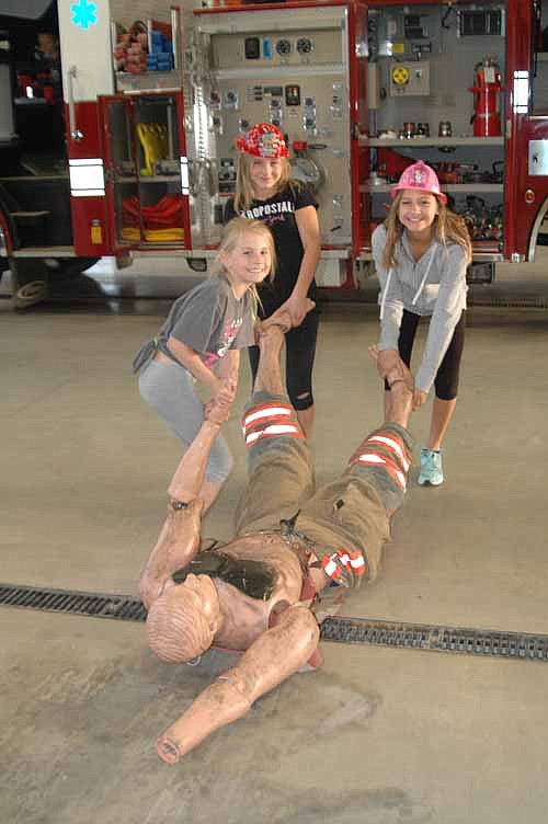 From left, Adrianna Franke, Mya Mead and Destiny Mead assist "Rescue Randy," a training mannequin at the SFD Open House.