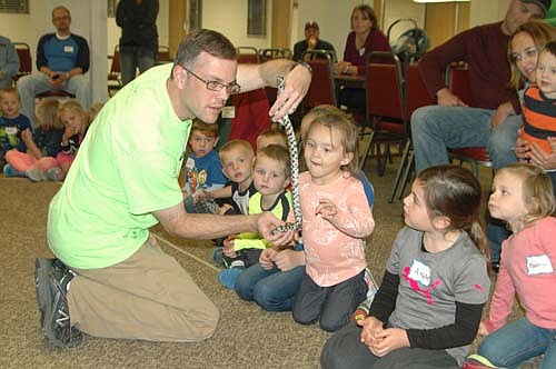 Adyson Pyfferoen, a student at St. John's Wee Care in Stewartville, center, examines a snake held by Travis Meyer, a naturalist from the Quarry Hill Nature Center, at St. John's Lutheran Church on Tuesday, Oct. 6. Other Wee Care children include, from far left, Jack Whitacre, Blain Sorenson, Liam O'Neill and Aubrey Whitacre.