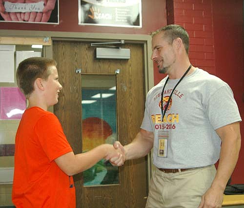 Chad Harlander, director of the REACH program at Hutchinson High School, right, shakes hands with Jack Parry, son of Jim Parry, coordinator of the REACH program at Stewartville Middle School.