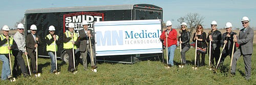 Jim Conway, standing sixth from left, and his brother Philip, at far right, joined by Stewartville city officials and other associates, broke ground last week for a 6,500 square-foot building for Minnesota Medical Technologies, a company that will produce a product designed to help people suffering from fecal bowel incontinence.  Fellow company founders include Sarah Grinde, fifth from right; and Lonnie Boe, fourth from right.