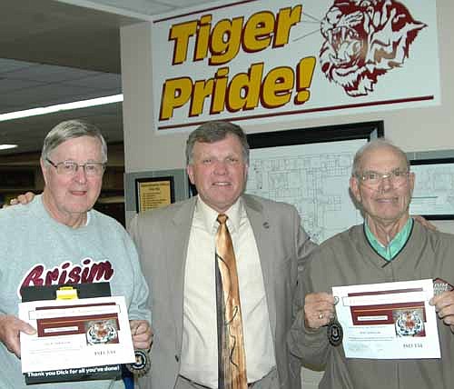 Dick Johnson, left, and Del Johnson, right, accepted Tiger Tokens and certificates from Dr. David Thompson, superintendent of the Stewartville School District, center. 