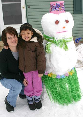 GRASS-SKIRTED SNOWMAN -- Tina Gordon and her daughter Penelopea worked together for about two hours to build a grass-skirted snowman in the front yard of their Stewartville home last week. "Penelopea came up with the idea for the skirt," Tina said. 
