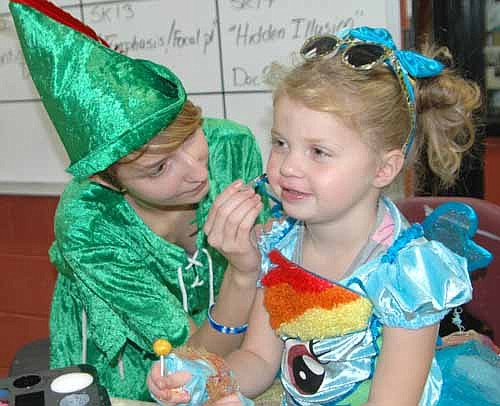 Paige Pettit, a senior at Stewartville High School, left, paints the face of Savannah Fay, 4, of Stewartville, who dressed like Rainbow Dash from My Little Pony at the SHS Key Club's Halloween Trick-or-Treat Night on Saturday, Oct. 31.