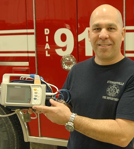 Vance Swisher, Stewartville fire chief, displays the Stewartville Fire Department's new "vitals" machine, purchased courtesy of a $3,000 grant from AgStar Financial Services.