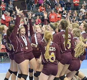 After beating third-ranked Rocori 3-2 and receiving their bronze medals, the Tiger captains hoist the MSHSL Class AA Volleyball State tournament third-place trophy over their heads as the rest of the Stewartville team rushes on to the court to join in the celebration.