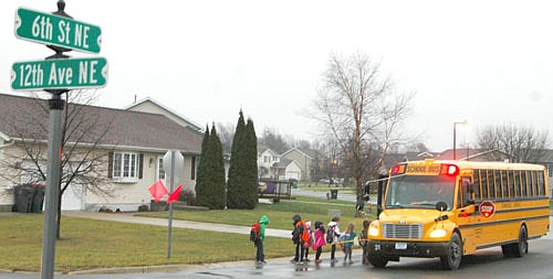 Children prepare to board a school bus near the intersection of Sixth Street Northeast and 12th Avenue Northeast on Tuesday morning, Nov. 17. At a recent meeting, the Stewartville City Council agreed to place stop signs to control the traffic flowing from east to west at the intersection, which established a four-way stop to make the intersection safer for children who enter and exit their school bus there.