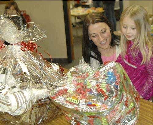 Liz Hyke and her daughter Zoey look over a few of the more than 40 items for sale for a silent auction at St. John's Wee Care's 20th annual One-Stop Christmas Shop at St. John's Lutheran Church on Friday evening, Nov. 20. Zoey, 4, is in the Butterfly class at Wee Care. Hundreds of Stewartville and area residents browsed among the many businesses at the event, including Usborne Books, Mary Kay, Lemongrass Spa, Creations for Donations, Avon and many more. Proceeds from the event went to Wee Care.