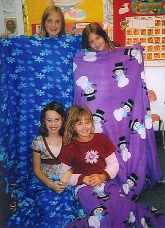 Girl Scout Troop 325 shows off the quilts they made for patients at the Ronald McDonald House in Rochester. Beginning in mid-September through the first part of December, the troop raised $114 by doing extra chores or donating their allowances. The money raised was used to shop for toys for the Toys for Tots program.  Pictured above are troop members Ashlyn Evans and Gabrielle Steinhoff, left to right, front, and back row left to right, Kaitlin Einertson and Emma Manning.  
