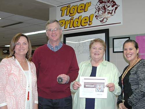 Byron Meline, pastor of Zion Lutheran Church, second from left, and Iz Wilken, a member of the church, accepted Tiger Tokens from Sheila McNeill, principal of Central Intermediate School, far left, at the Stewartville School Board's meeting last week. Meline, Wilken and other members of Zion Church have helped with the Stewartville School District's backpack program, which provides food for local residents in need. Courtney Fakler, a social worker at Bonner Elementary School and at Central, who also helps with the program, is at far right.