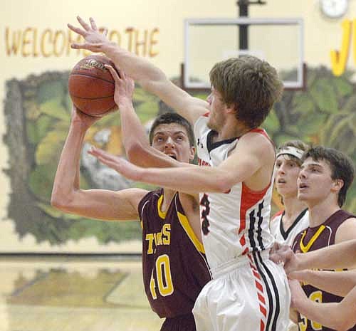 Carter Groski battles under the iron for this put-back bucket against KW.