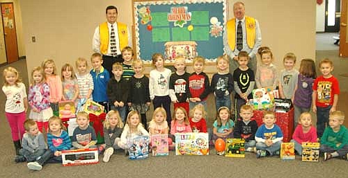 Troy Knutson, left, and Bill Schimmel Jr. of the Stewartville Lions Club, standing in back, visited St. John's Wee Care on Thursday, Dec. 3 to collect gifts donated by Wee Care families to the annual Lions Club Christmas Anonymous gift and fund drive. Each year, the Lions deliver the gifts to a distribution center in Rochester, where the presents are made available to Olmsted County children who otherwise might not receive a Christmas gift.