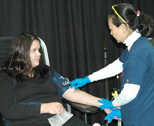 Courtney Markwardt, a senior at Stewartville High School, left, gives blood at the Mayo Clinic Blood Drive at SHS on Tuesday, Dec. 1. Nghia Le, a phlebotomist for Mayo Clinic's blood donor services, is at right.