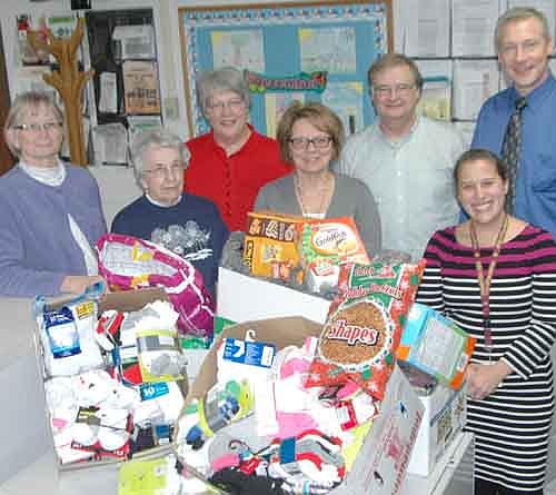 Pastor Lyle Fritsch, third from right, and members of St. John's Lutheran Church dropped off a large supply of socks and snacks for the students at Bonner Elementary School on Wednesday, Dec. 16. Courtney Fakler, school social worker at Bonner and at Central Intermediate School, far right in the front row, said several students at Bonner come to school without socks, and others can't afford to bring snacks. Members of St. John's Church recently deposited the items into a laundry basket in the church narthex. Church members thanked Thrivent Financial for a significant donation to help pay for the items. Church members include, from left, Kathy Tordsen, Nancy Henke, Mary Boettcher, Deb Sloneker and Pastor Fritsch. At far right are Courtney Fakler and Matt Phelps, principal of Bonner Elementary School.