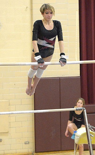 Paige Pettit swings up into an uprise to a free hip on the bars against the Panthers.
