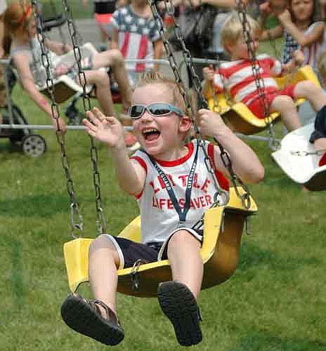 Ryan Clapp, 4, greets his grandmother with a wave and a smile as he enjoys the swing ride at the Stewartville Area Chamber of Commerce's Summerfest celebration on Saturday, July 4.