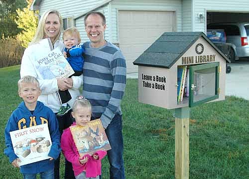 C.J. and Carrie Boerger and their children, Charlie, 7; Chloe, 4; and Caleb, 17 months, welcome local and area residents to check out books from the already-popular mini library at a corner of their front lawn at 611 Twelfth Avenue Southeast.