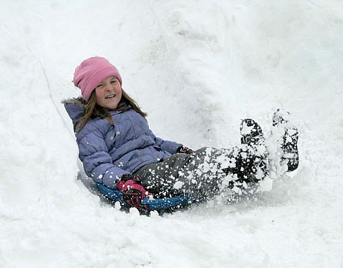 Olivia Larson, a third grader at Central, kicks up some snow at the end of her downhill journey during recess on Jan. 7.