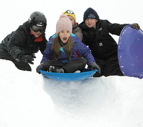 Katherine Jones, a third grader at Central Intermediate School, is aghast at the sudden drop-off as she prepares to head down the sledding hill near the school on Thursday, Jan. 7. Assisting Katherine are third graders Graysen Schneider, left, and Ray Laures, right.
