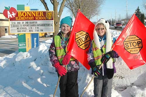Emma Zahradnik, left, and Addie Haugen, third graders at Bonner Elementary School, worked as School Patrol crossing guards near the school last Wednesday afternoon, Jan. 13. Both said they enjoy their jobs. "It's fun to stop cars," Emma said. Addie agreed. "I like helping the other children get across,"&#8200;she said.