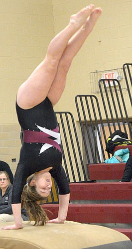 Maggie Beach executes a handspring on the vault with parallel legs and pointed toes.