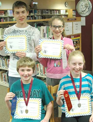 Noah Laures, a seventh grader, seated at left, placed first among 36 students in the Stewartville Middle School spelling bee at the Performing Arts Center last week. Noah correctly spelled "seltzer" in the 12th round to win the contest. Lydia Fryer, a sixth grader seated at right, placed second. Standing from left are Nicholas Bode, an eighth grader who placed fourth; and Mckenna Pickett, a seventh grader who placed third.