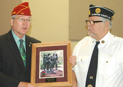 Dale Barnett, national commander of the American Legion, left, accepts a gift from Richard Paulson, first vice commander of the Stewartville American Legion Post 164, on Thursday, Feb. 4. The gift is a picture of the Vietnam Veterans Memorial in Washington D.C. Paulson took the photo and framed the picture. Paulson filled in for Dean Ramaker, commander of the Legion, who was unable to attend Barnett's visit to Stewartville.