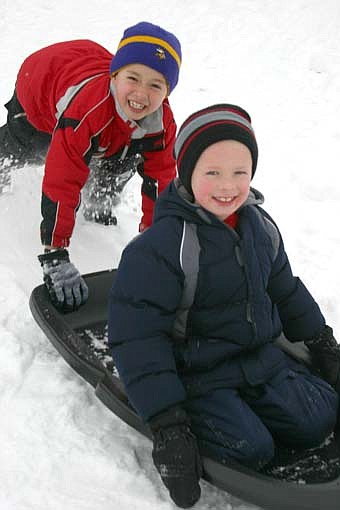 Bonner Elementary School students enjoyed jumping on their sleds and heading down the hill near the school during recess last week. Here, Blake Ellerbusch, seated, as his friend Nathan Johnson gives him a push. 