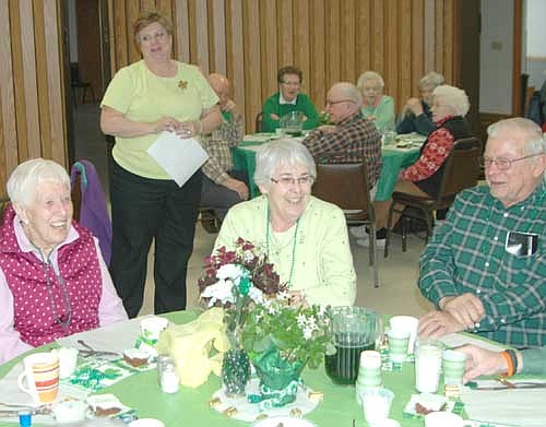 Jill Hildebrandt, site coordinator for the Center for Active Adults, in the background at left, hosted a St. Patrick's Day luncheon at the Stewartville Civic Center on Thursday, March 17. Guests drank green beer and ate corned beef and cabbage, and Hildebrandt wished a happy birthday to Ferrolyn Hildebrandt, her mother-in law, seated in center. Others seated in front include Anna Fahrman, left, and Jerry Hildebrandt, right.