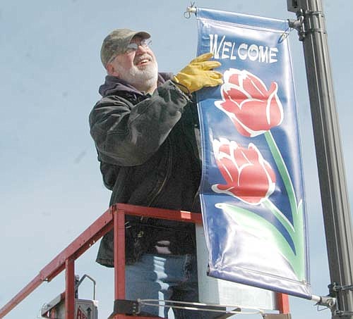 Scott Priebe of the city of Stewartville's public works department placed the city's spring welcome banners on the light poles along Main Street on Monday, March 21.