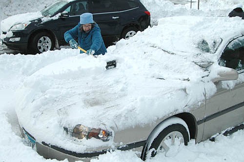 Jean Gooderum, a resident of the Downtowner II&#8200;in Stewartville, scrapes the snow off her car after an early-spring snowstorm socked Stewartville and the area with about 10.5 inches of snow on Wednesday, March 23 and Thursday, March 24. Gooderum cleared her car of snow so she could drive to lunch at the Center for Active Adults on Thursday morning, March 24.