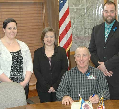 Mayor Jimmie-John King, seated, signed a proclamation last week declaring April Child Abuse Prevention Month in the city of Stewartville. Standing, from left, are Nicole Draxler, Crisis Nursery practicum student for Families First; Allison Johnson, coordinator of the Crisis Nursery for Families First of Minnesota; and Rich Fakler of Home Federal. Draxler, Johnson and Fakler are all members of the Voices for Children Committee.
