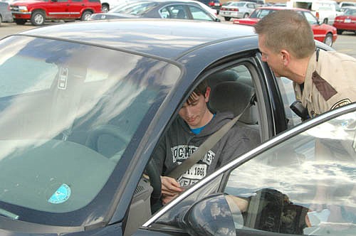 Kade Weber, a senior at Stewartville High School, accepts a coupon for a free Blizzard at Stewartville's Dairy Queen from Jens Dammen, a sergeant with the Olmsted County Sheriff's Office, in the SHS parking lot on Friday afternoon, April 15. Fifty SHS students who used their seat belts that afternoon each received a free Blizzard treat. "We want to share a little positive reinforcement for seat belt use," Dammen said.