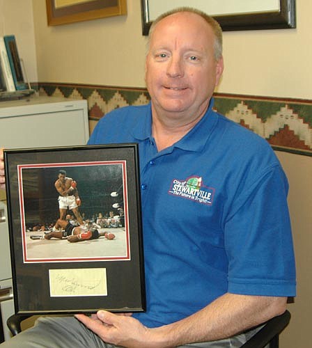 Bill Schimmel Jr., city administrator, displays the autograph he received from Muhammad Ali on July 7, 1980. The photo is one of Schimmel's favorites of Ali in action.
