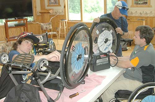 Campers Marcus Urban of Eagan, Minn., left, and Dayton Farley of Bismarck, N.D., right, join instructor Dave Norman of Dana Point, Calif. to work on wheelchairs at the National Wheelchair Sports Camp at Ironwood Springs Christian Ranch last Wednesday, June 15. About 75 campers attended the 30th annual camp.