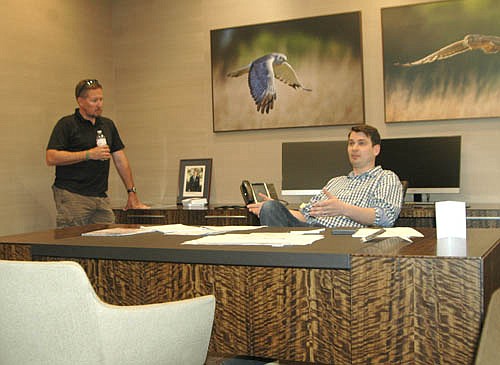 Ben Conway, president of Halcon, right, seated at the desk of his father, Peter Conway, Halcon's founder and chairman, speaks to the EDA during a tour of Halcon's new administration building on Tuesday, June 21. Councilperson Craig Anderson, a member of the EDA, is at left.