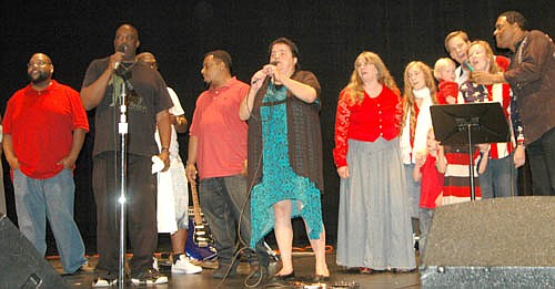 Gloria Nihart of Stewartville, center, who organized Gospel Music Bash #3 at the Stewartville High School Performing Arts Center on Thursday, June 30, leads her fellow performers in a rendition of God Bless America to get the concert off to a rousing start. Dion Pride, far right, was inducted into America's Old Time Country Music Hall of Fame during a break in the singing.