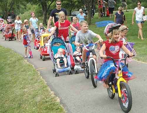All decked out in red, white and blue, participants in the Summerfest Kids Parade make their way down a path at Florence Park on the Fourth of July.
