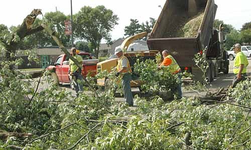 A summer storm packing winds of about 70 miles per hour roared through Stewartville and the area on Tuesday evening, July 5, damaging many trees. City of Stewartville workers clear tree branches near Bonner Elementary School.