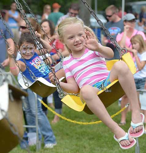 Maci Greenwood, 5, waves to her mother as she enjoys the swing ride at the Stewartville Area Chamber of Commerce's Independence Day Summerfest celebration on Monday, July 4.