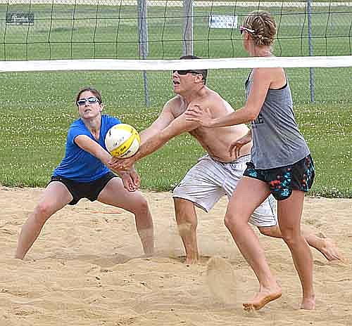 Laura Wiles digs the ball with Andrew Langseth as teammate Katie Bunne readies at the net.