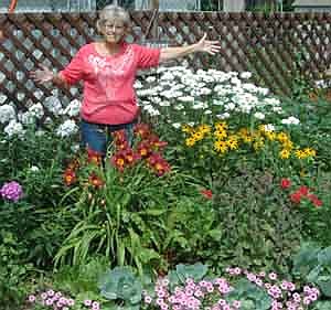 Anita Fjelstad of Stewartville stands among the flowers in her backyard garden along Third Street Northwest. "I retired to gardening," she said. "That's what I&#8200;love to do." Although rewarding, gardening isn't easy, she said. "It's a lot of work,"&#8200;she said. "I'm out here two or three hours a day, at least." Her garden includes daylilies, phlox, Shasta daisies and brown-eyed Susans.