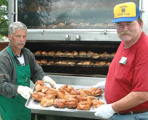 Scott Hurley of Parties Made Simple, left, shares a pan of chicken with Joe Dee, president of the Racine Lions Club, at the Lions Club's Chicken BBQ &&#8200;Dance on July 16. Hurley cooked 600 chicken halves for the guests at the event. Proceeds from the event pay for Racine Lions Club projects.
